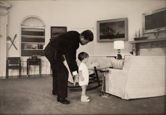 Photograph of President Kennedy and John Jr. in the Oval Office