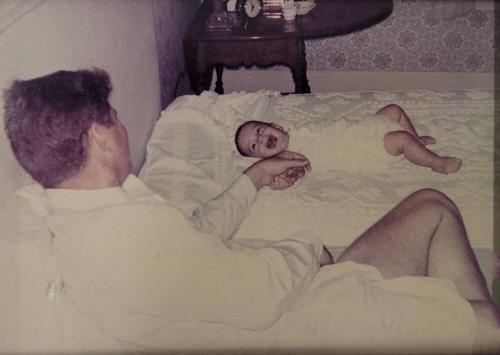 Photograph of President Kennedy with John Jr. Lying on a Blanket